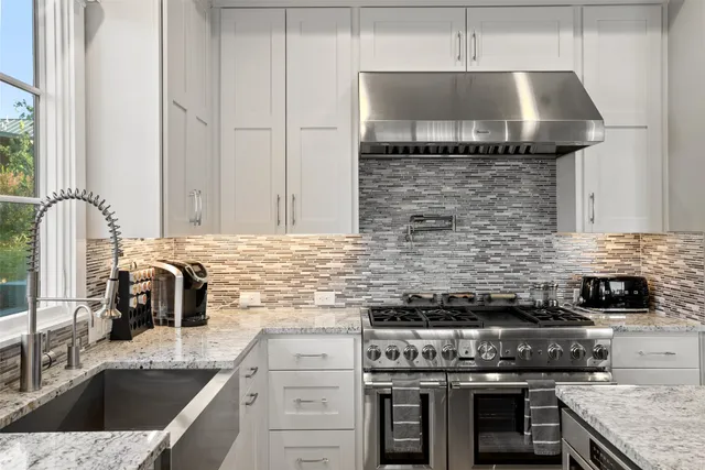 a living room with couches a flat screen tv and kitchen view