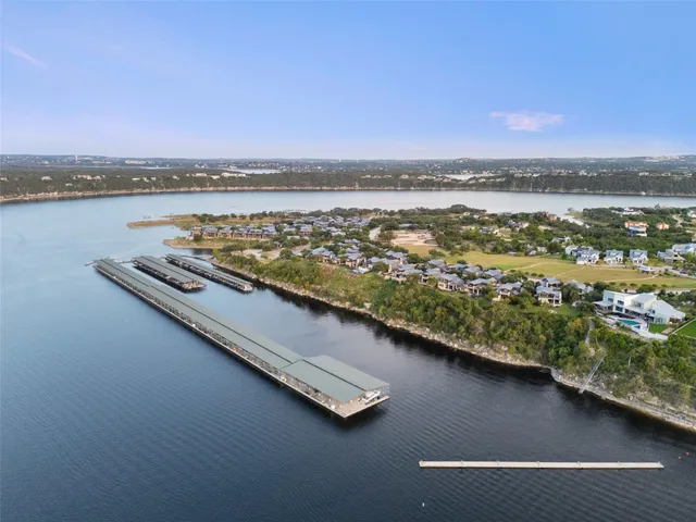 an aerial view of residential house with outdoor space and trees all around