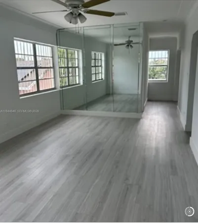 a view of a room with wooden floor and cabinets