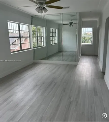 a view of a room with wooden floor and cabinets