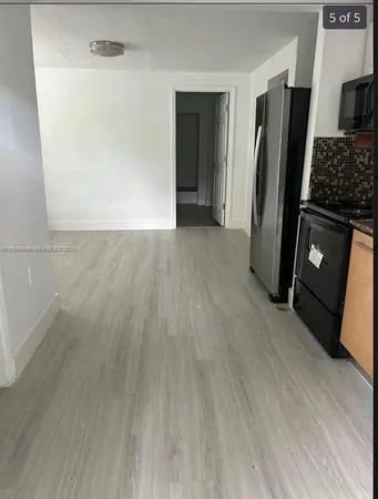 an empty room with wooden floor closet and a fireplace