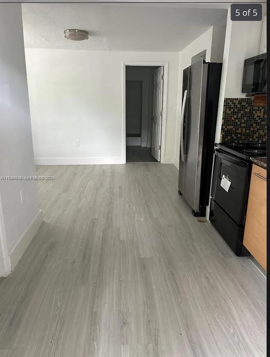 2215 Northwest 33rd Street Miami, FL 33142 - Photo 2 of 19 an empty room with wooden floor closet and a fireplace