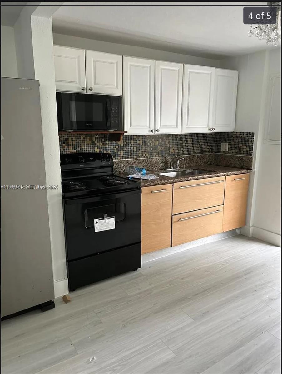 2215 Northwest 33rd Street Miami, FL 33142 - Photo 3 of 19 a kitchen with a stove and a microwave