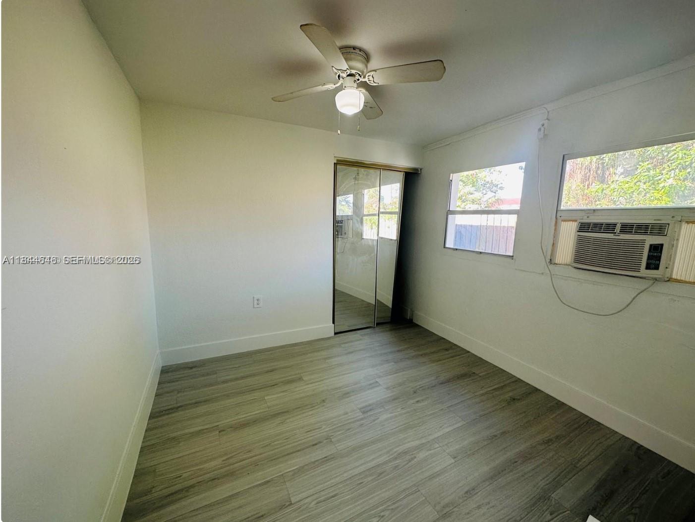 2215 Northwest 33rd Street Miami, FL 33142 - Photo 7 of 19 an empty room with wooden floor fan and windows