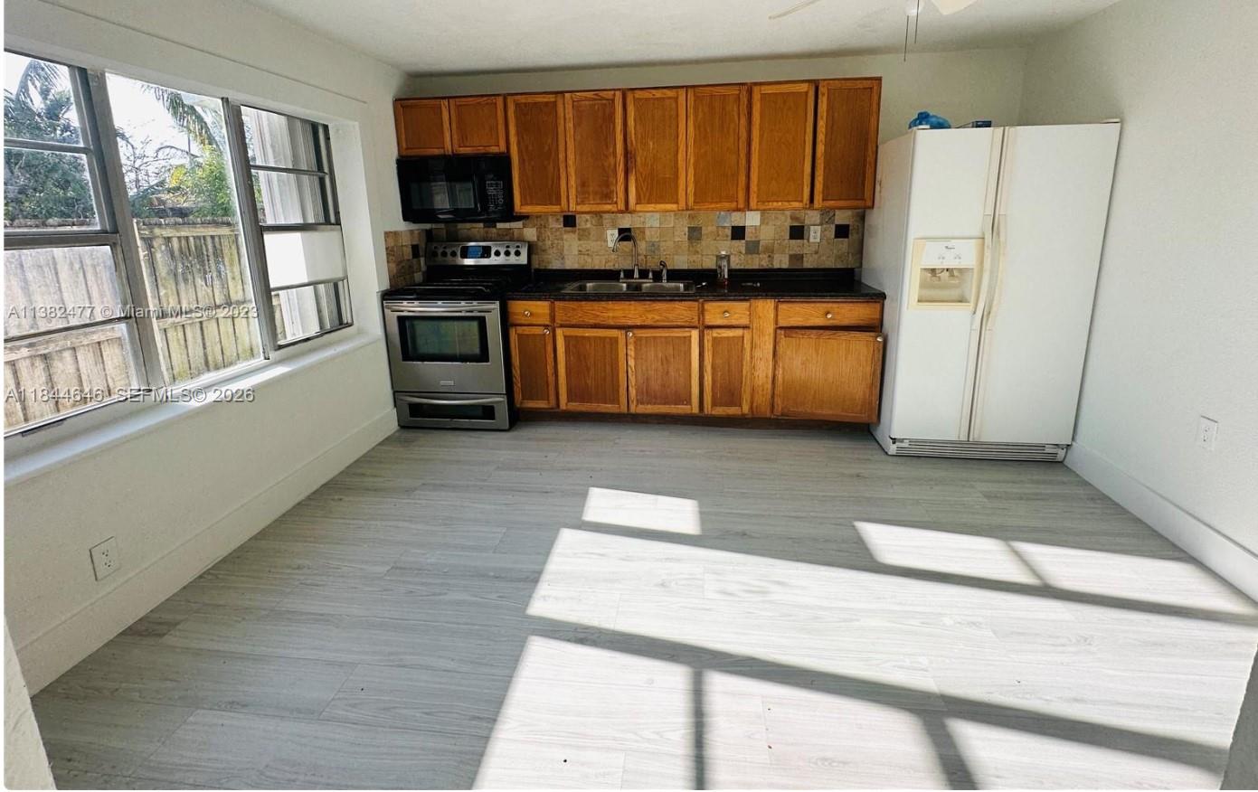 2215 Northwest 33rd Street Miami, FL 33142 - Photo 10 of 19 a kitchen with stainless steel appliances a refrigerator and a stove top oven