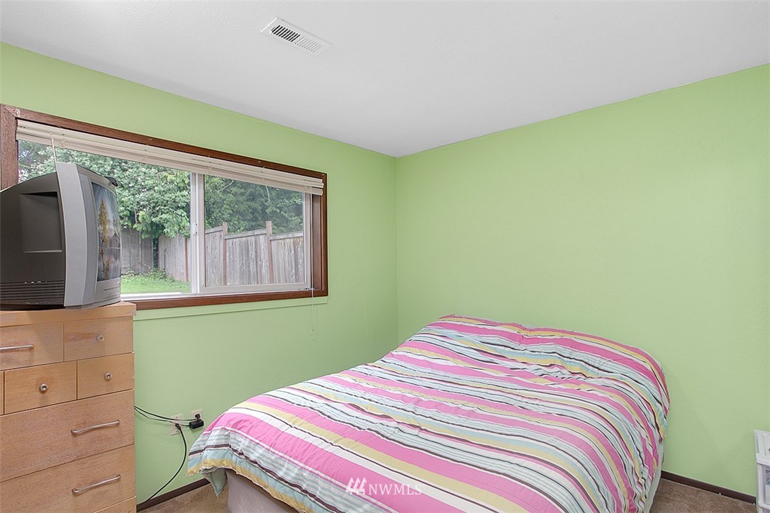 1722 225th Street Southeast Bothell, WA 98021 - Photo 14 of 19 a bedroom with a bed and a flat tv screen on dresser