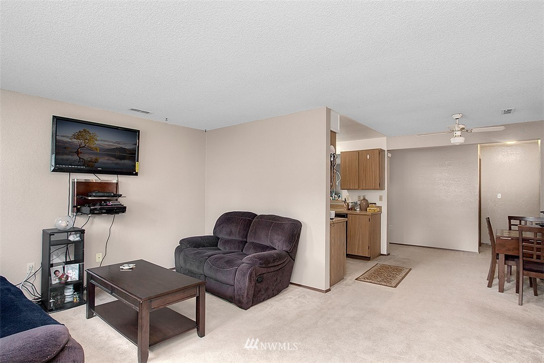 1722 225th Street Southeast Bothell, WA 98021 - Photo 4 of 19 a living room with furniture a flat screen tv and a refrigerator