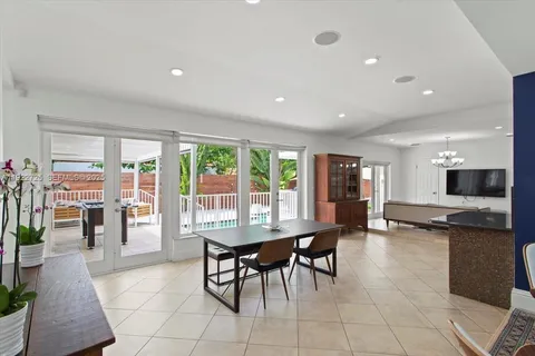 a dining room with furniture and large windows