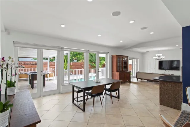 a dining room with furniture and large windows