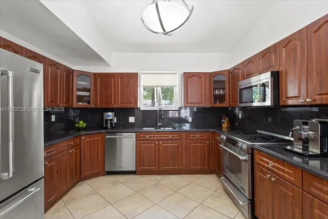 a kitchen with stainless steel appliances granite countertop a sink and cabinets