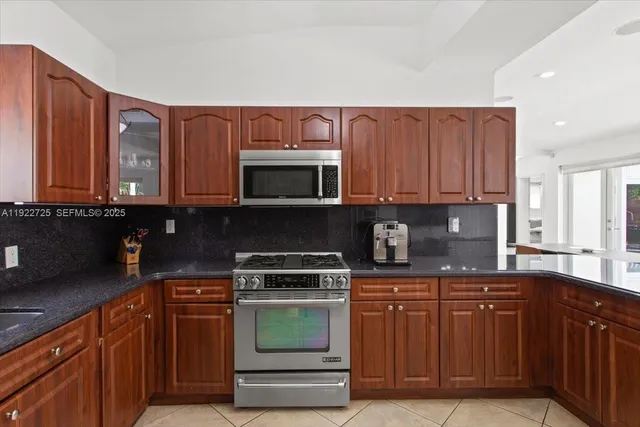 a kitchen with stainless steel appliances granite countertop a stove and a microwave