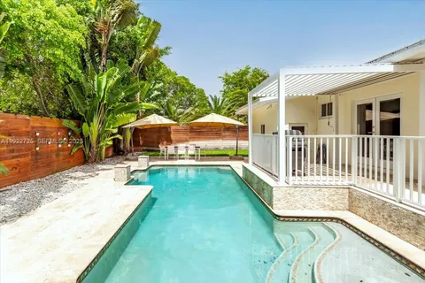 a view of a house with backyard and sitting area