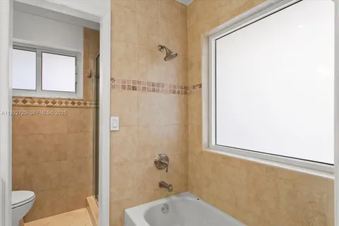 a bathroom with a granite countertop shower a toilet and a sink