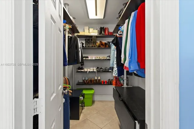 a view of walk in closet with clothes and shoes