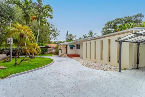 a view of road with house and trees in the background