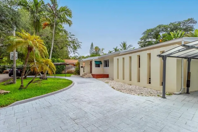 a view of road with house and trees in the background