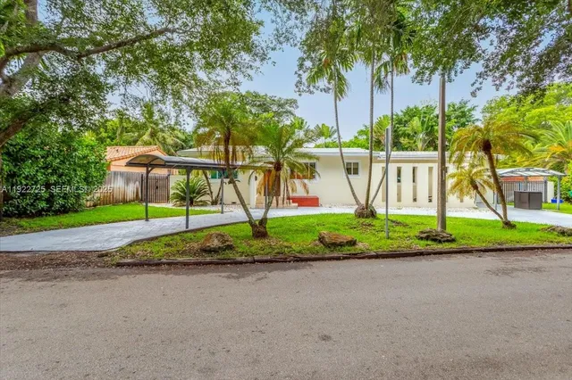 a view of a house with backyard and trees