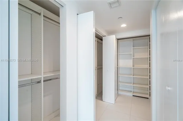 a view of walk in closet with empty racks