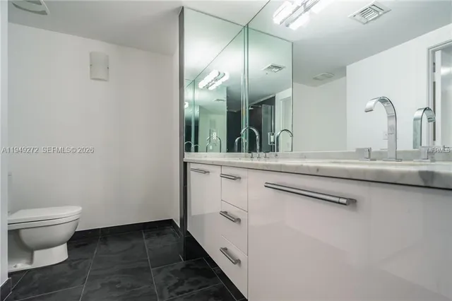 a bathroom with a double vanity sink and a toilet