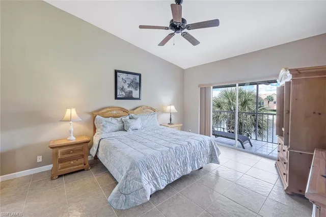 a bedroom with a bed painting on wall and a large window