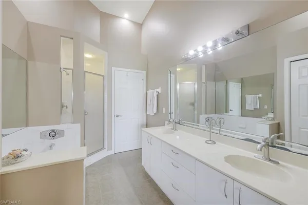 a large bathroom with a double vanity sink a large mirror and shower