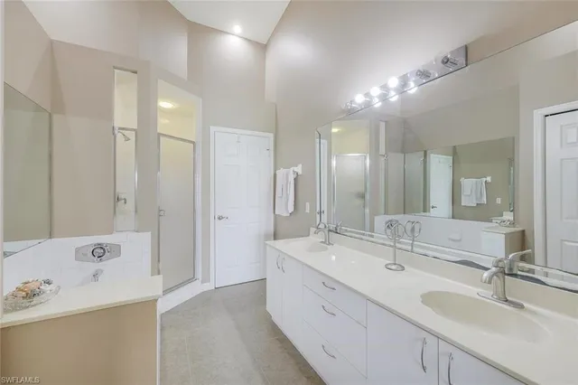 a large bathroom with a double vanity sink a large mirror and shower