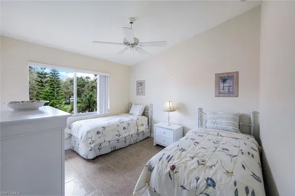 a bedroom with two beds and a large window