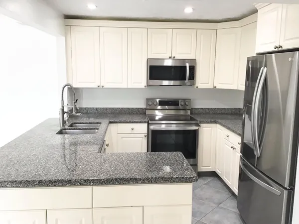 a kitchen with kitchen island granite countertop stainless steel appliances and a counter top space