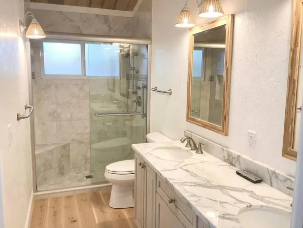 a bathroom with a granite countertop sink a toilet and shower