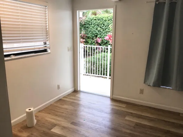 a view of a room with wooden floor and a window