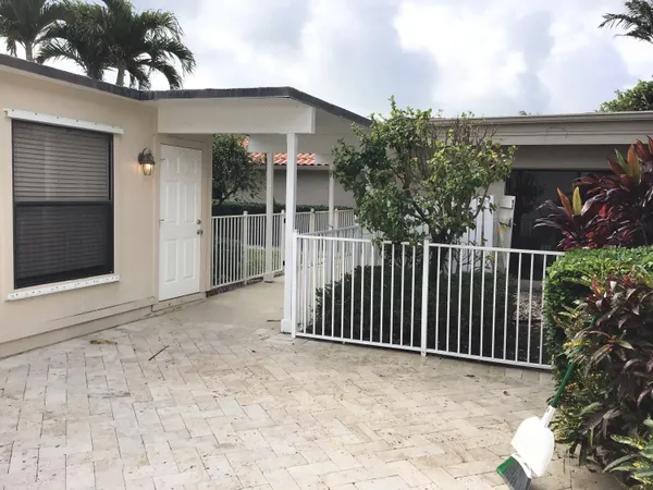a view of a house with a yard and potted plants