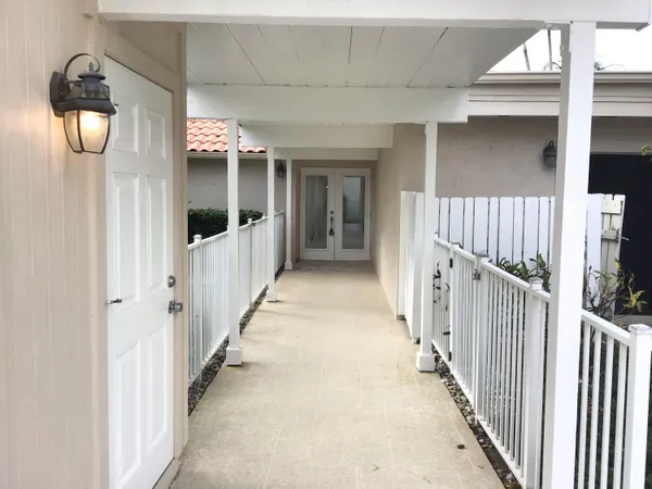 a view of a hallway with wooden floor and entryway