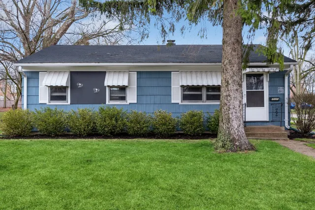 a front view of a house with a garden and yard