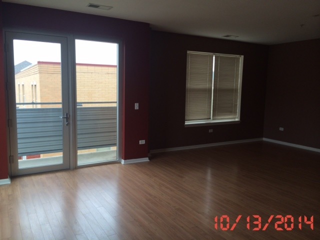 3522 South State Street, Unit 301 Chicago, IL 60609 - Photo 4 of 12 an empty room with wooden floor and windows