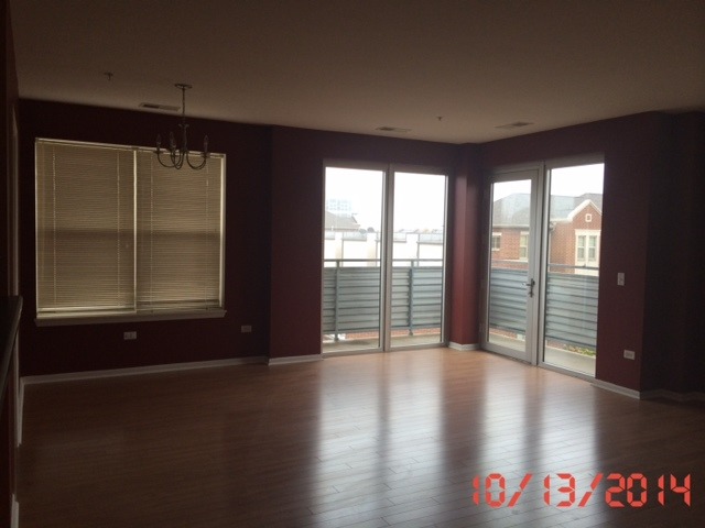 3522 South State Street, Unit 301 Chicago, IL 60609 - Photo 5 of 12 an empty room with wooden floor and windows