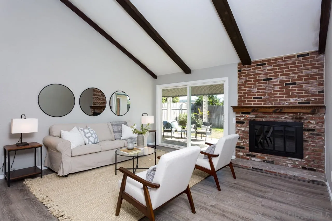 14427 Mirando Street Poway, CA 92064 - Photo 2 of 33 a living room with couches a fireplace and a large mirror with wooden floor