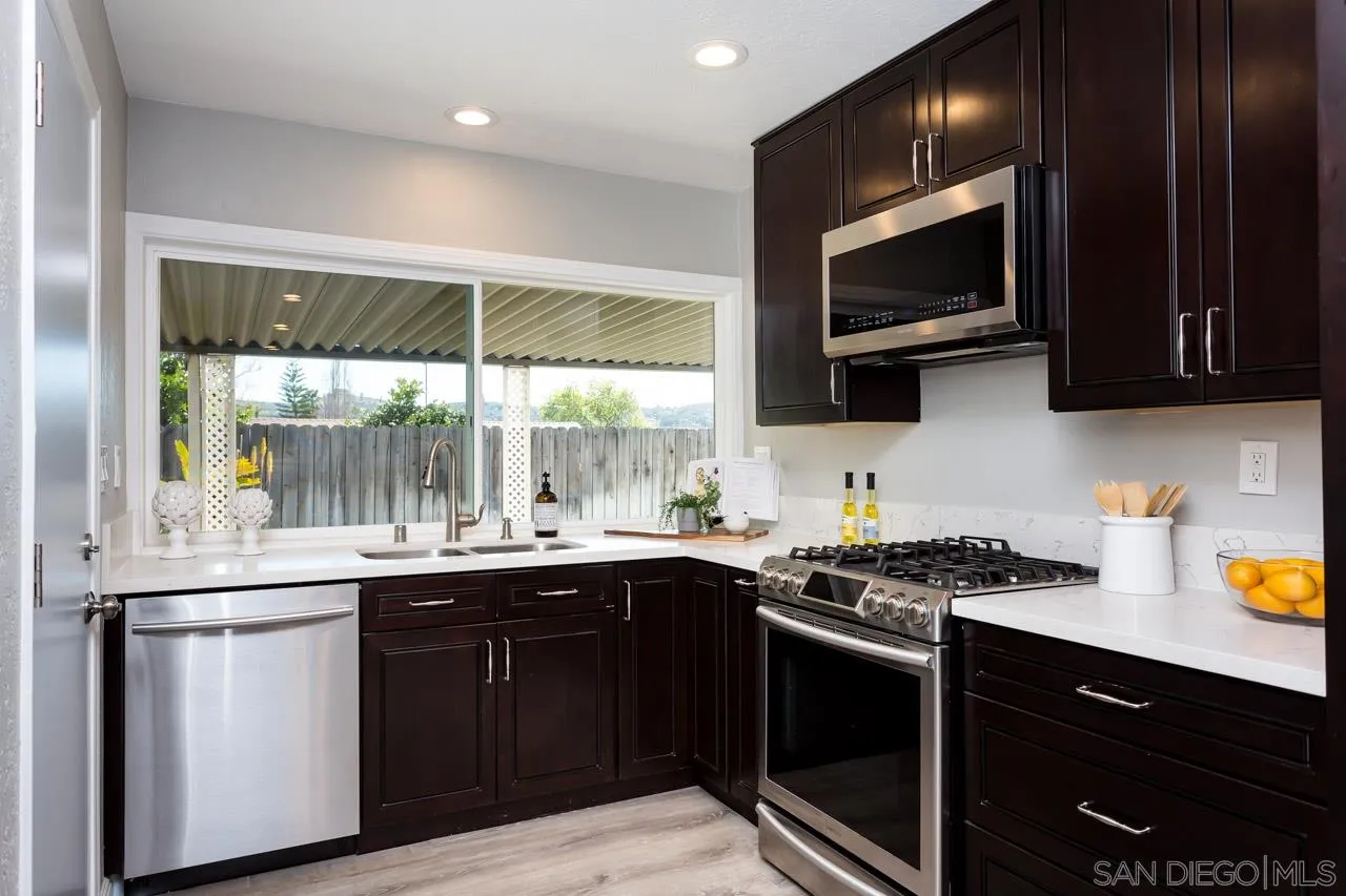 14427 Mirando Street Poway, CA 92064 - Photo 6 of 33 a kitchen with a sink stove and microwave