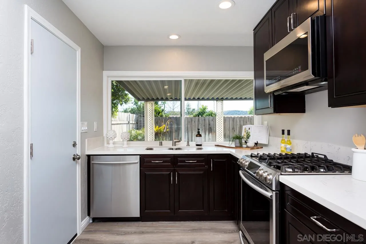 14427 Mirando Street Poway, CA 92064 - Photo 7 of 33 a kitchen with a sink stove top oven and cabinets