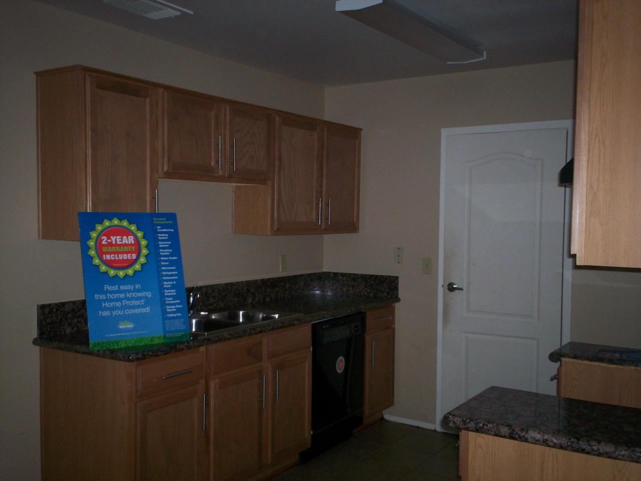 3511 East Baseline Road, Unit 1166 Phoenix, AZ 85042 - Photo 3 of 5 a kitchen with granite countertop cabinets and black appliances