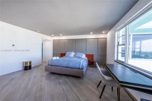 a spacious bedroom with a bed and a large window