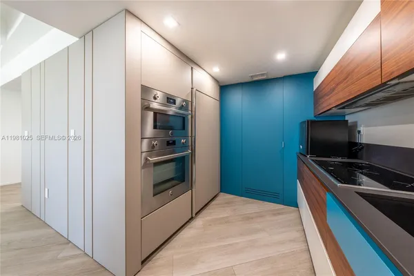 a kitchen with stainless steel appliances and granite countertop wooden cabinets
