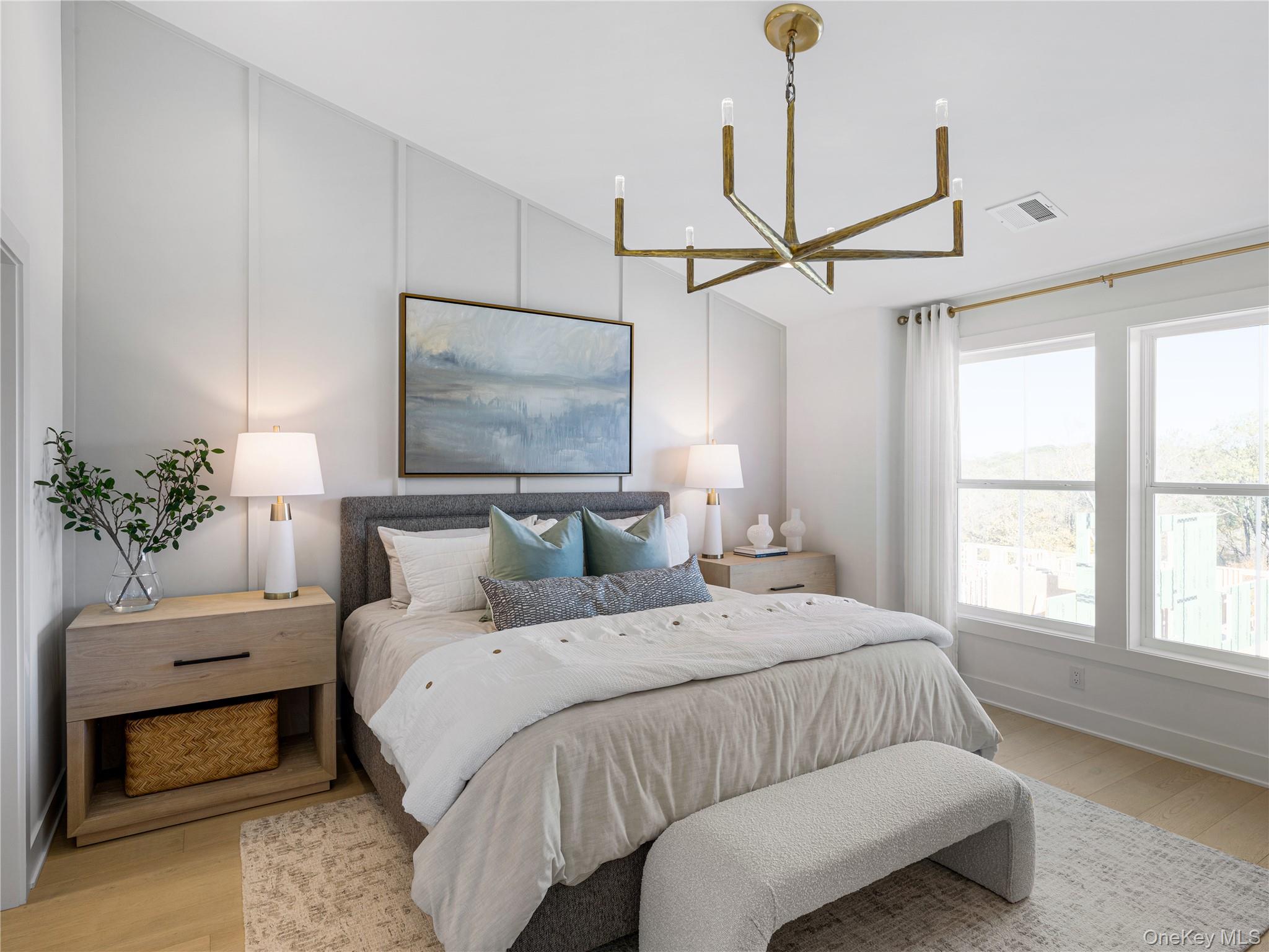 5110 Teaberry Lane, Unit 31 Fishkill, NY 12524 - Photo 4 of 10 Bedroom featuring light wood-style floors, a decorative wall, a chandelier, and lofted ceiling