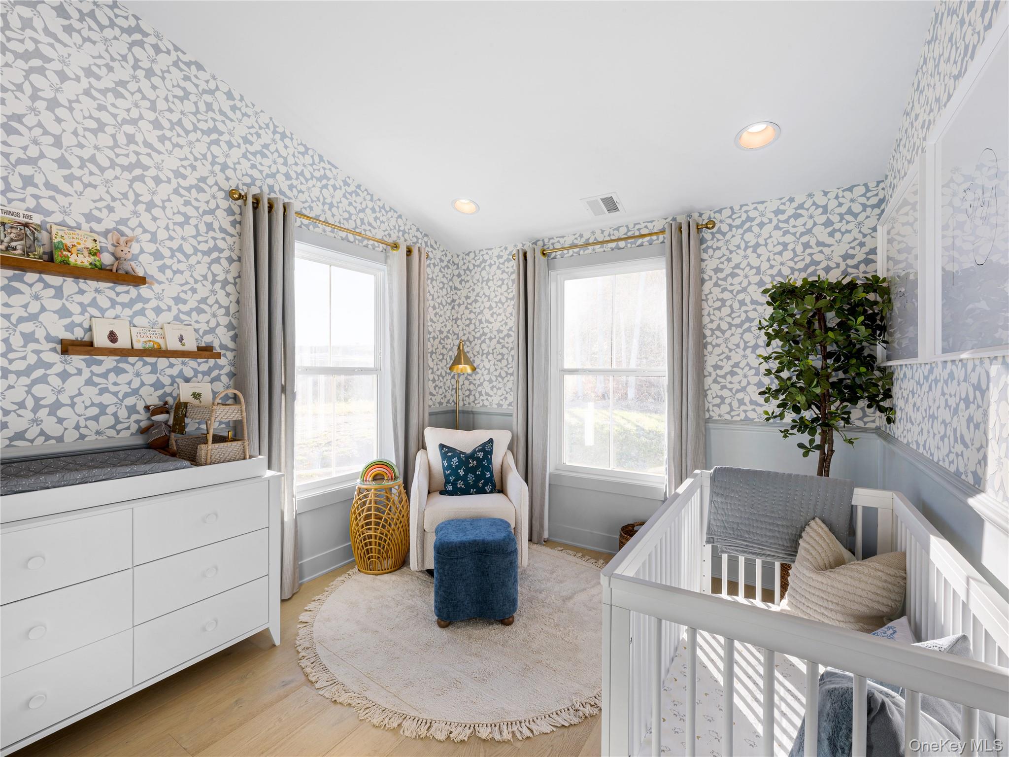 5110 Teaberry Lane, Unit 31 Fishkill, NY 12524 - Photo 7 of 10 Bedroom featuring wallpapered walls, vaulted ceiling, a nursery area, light wood finished floors, and wainscoting