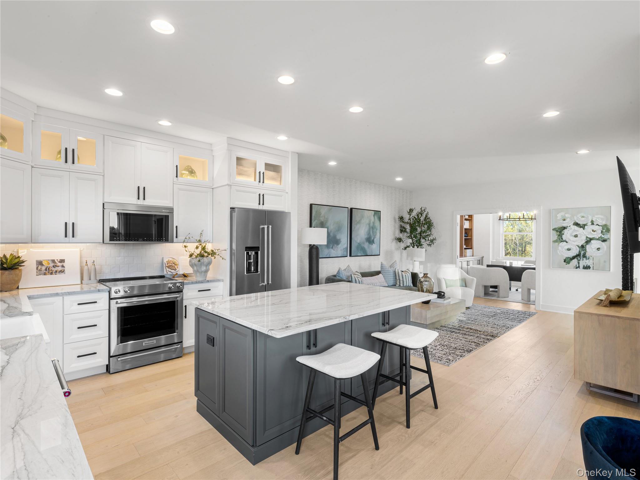 5110 Teaberry Lane, Unit 31 Fishkill, NY 12524 - Photo 10 of 10 Kitchen featuring light stone counters, white cabinetry, a breakfast bar area, stainless steel appliances, and a kitchen island