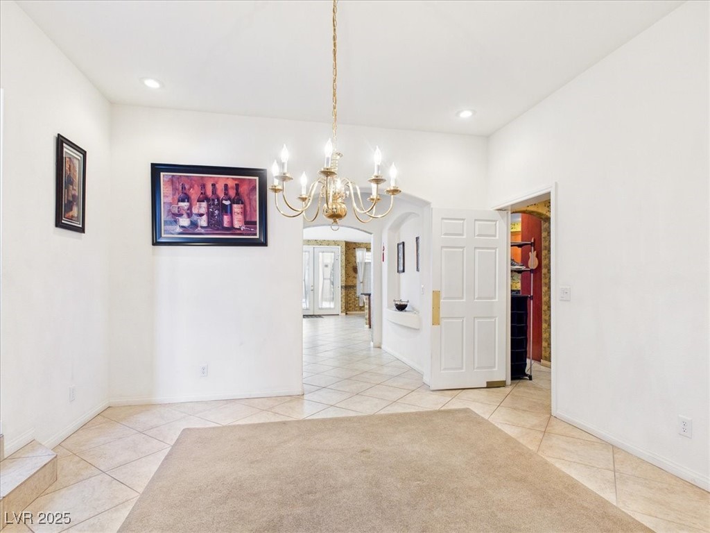 321 Whispering Tree Avenue Las Vegas, NV 89183 - Photo 19 of 95 Unfurnished dining area with light tile patterned floors, a chandelier, arched walkways, and recessed lighting
