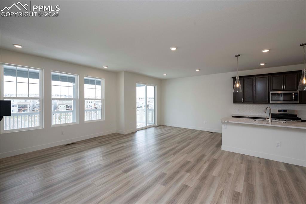 2042 Peachleaf Loop Castle Rock, CO 80108 - Photo 12 of 26 a view of an empty room with a window and wooden floor