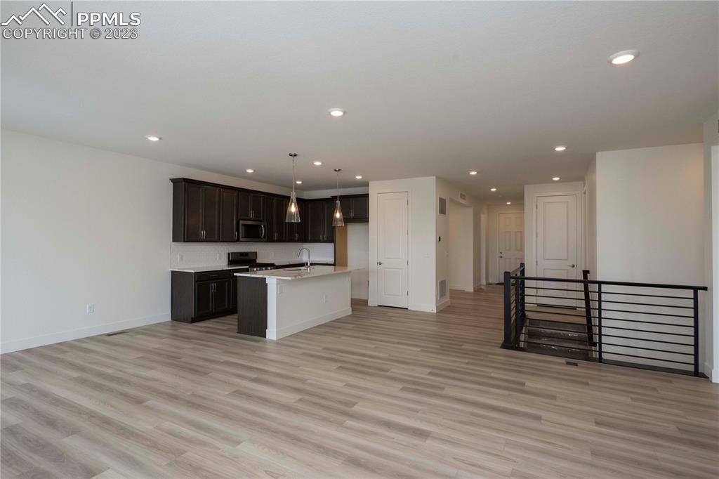 2042 Peachleaf Loop Castle Rock, CO 80108 - Photo 13 of 26 a large white kitchen with kitchen island a sink stainless steel appliances and cabinets