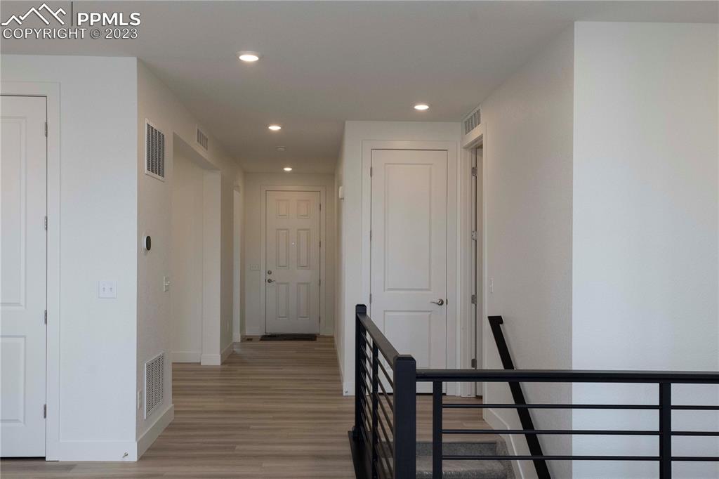2042 Peachleaf Loop Castle Rock, CO 80108 - Photo 3 of 26 a view of a hallway with wooden floor and staircase