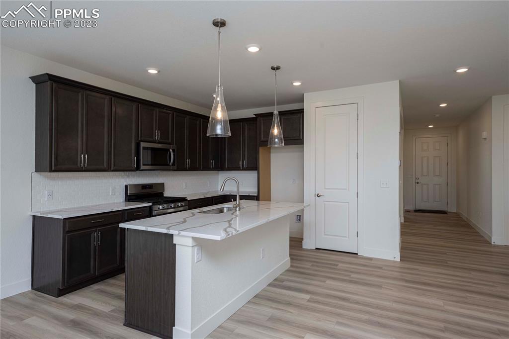 2042 Peachleaf Loop Castle Rock, CO 80108 - Photo 8 of 26 a kitchen with a sink a stove and cabinets