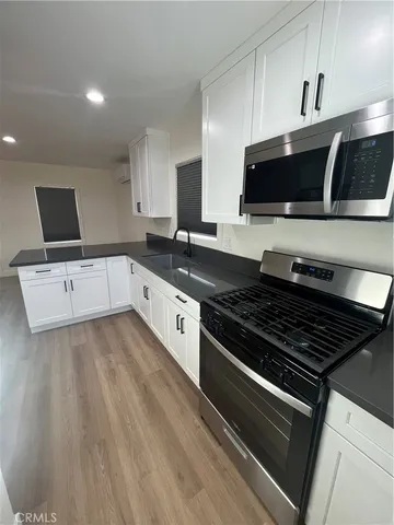 a view of a refrigerator in kitchen and a wooden floor